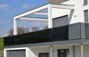 Balkon mit verglastem Edelstahl-Geländer an der Fassade eines modernen Wohnhauses